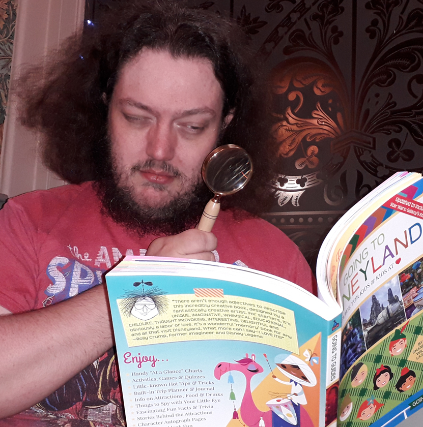 Editor Hugh Allison examines the book Going To Disneyland with a magnifying glass